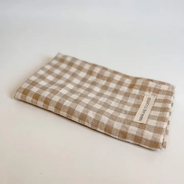 Folded checkered fabric with a brand label on a light background