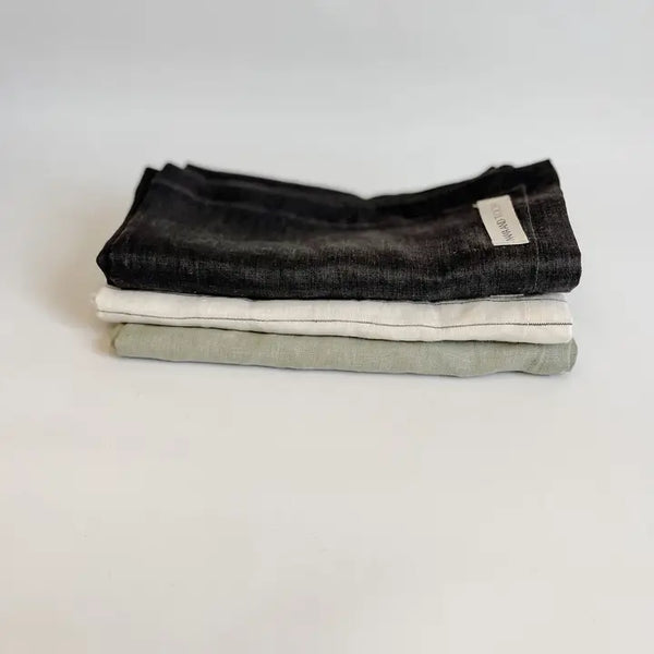 Stack of folded tea towels on a light gray background