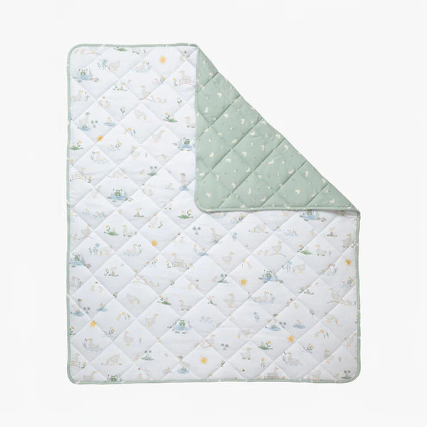 Quilted baby blanket with animal pattern on one side and solid color on the other, on a white background.