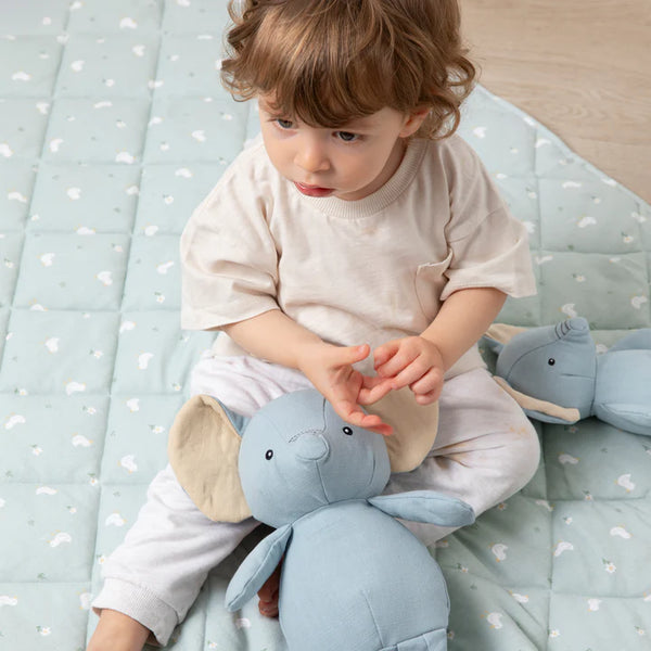 Child playing with a plush toy on a soft surface