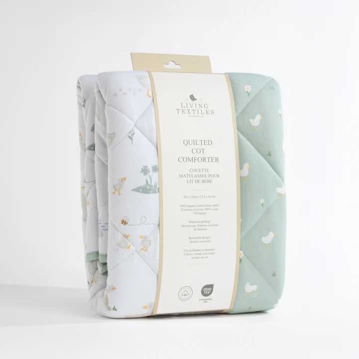 Quilted cot comforter with packaging on a white background