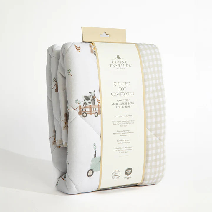Quilted cot comforter with packaging on a white background