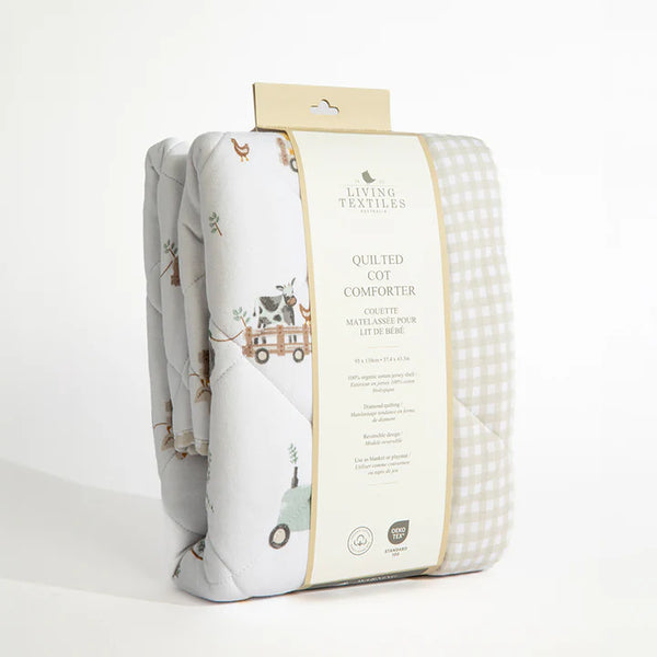 Quilted cot comforter with packaging on a white background
