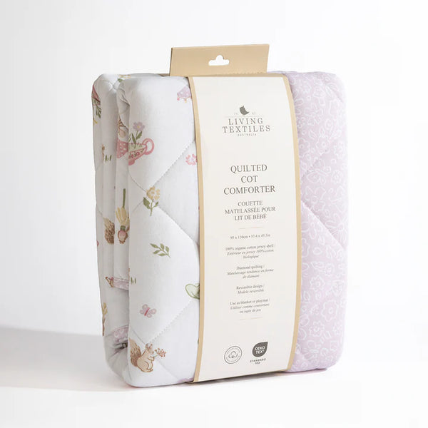 Packaged quilted cot comforter with floral design on a white background