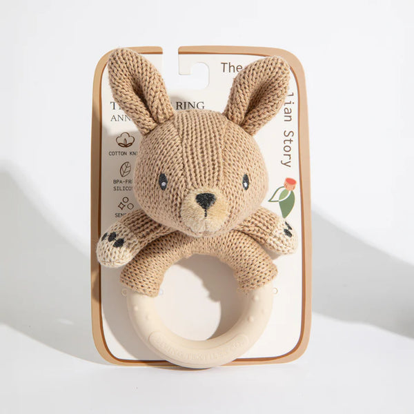 Knitted bear rattle with wooden ring on a white background