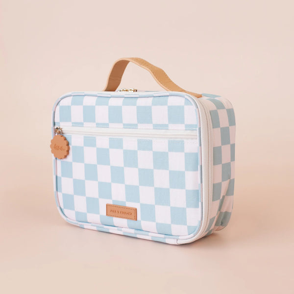 Checkered lunch bag with brown handle and tag on a beige background