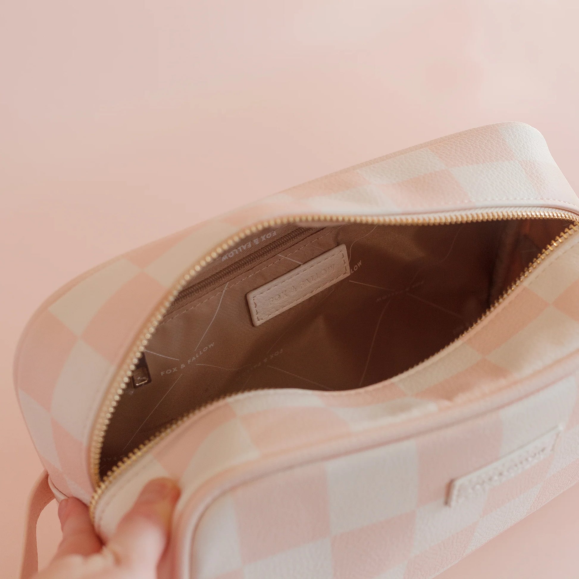 Pink checkered bag with a visible brand label on a pink background