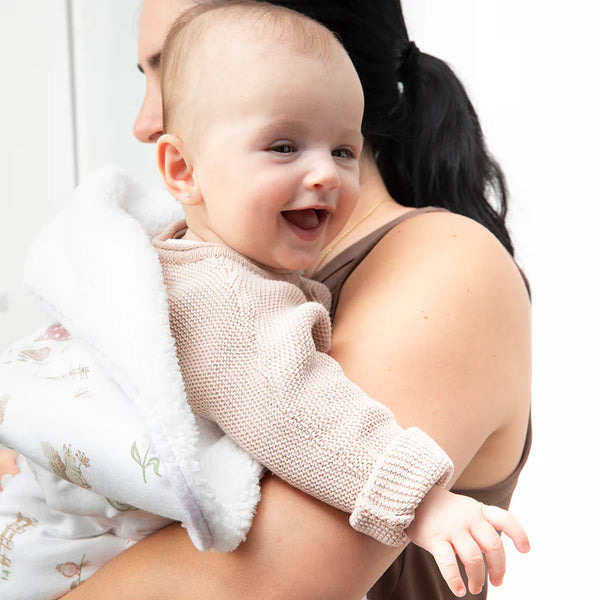 Baby being held by a person with a white background