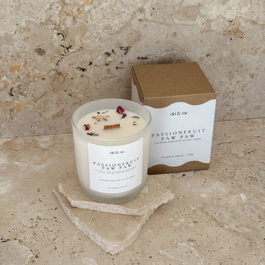 Candle with a decorative label and packaging on a stone surface