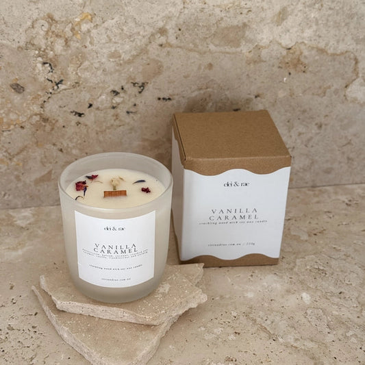 Vanilla caramel candle with packaging on a stone surface 