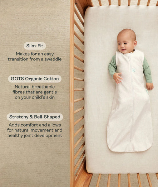 Baby in a white organic cotton swaddle in a crib with text describing its features.