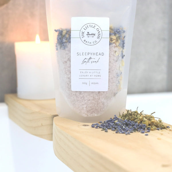 Bath salt packaging with a candle and lavender on a wooden board