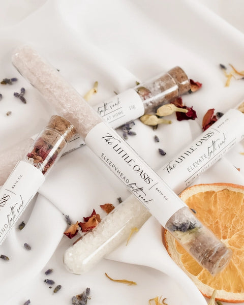 Bath soak container bottles with dried flowers and orange slices on a white background
