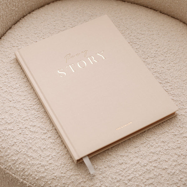 Beige notebook with 'Your Story' text on a textured surface