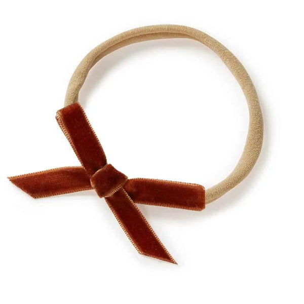 Beige headband with a brown velvet bow on a white background