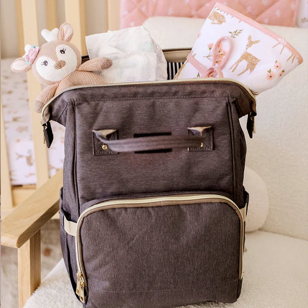 Brown diaper bag with baby items on a couch