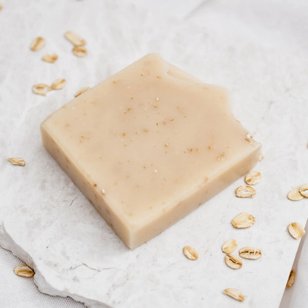 Bar of soap with oatmeal pieces on a light background