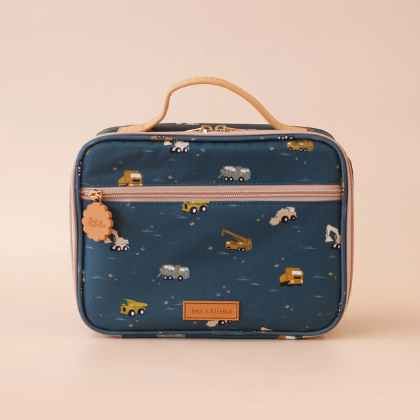 Blue lunch bag with toy truck pattern on a beige background