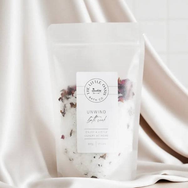 Bath soak package with floral elements on a soft fabric background