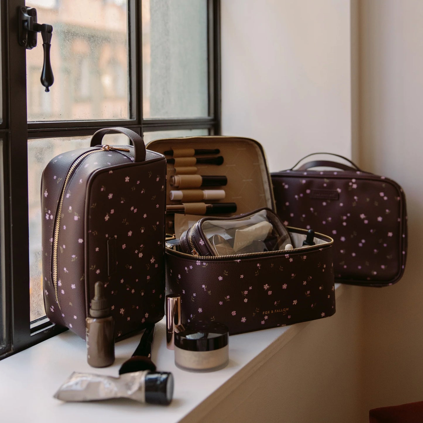 Makeup bag with brushes and products on a windowsill