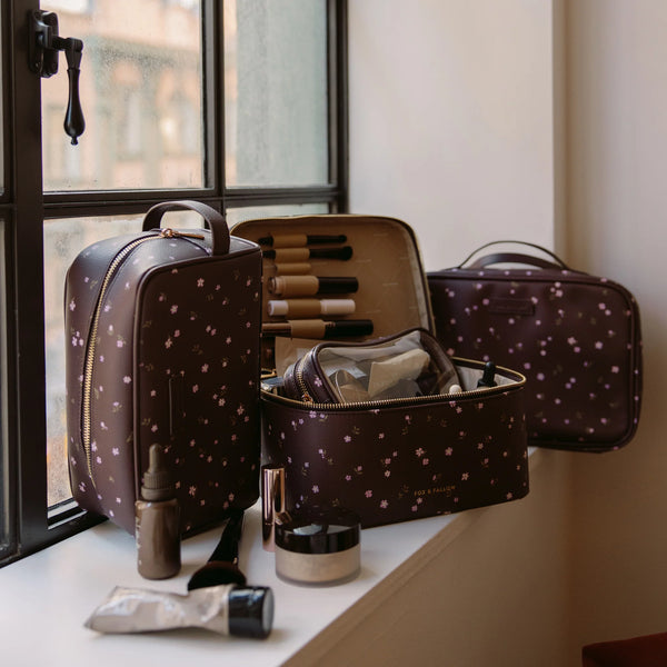 Makeup bag with brushes and products on a windowsill