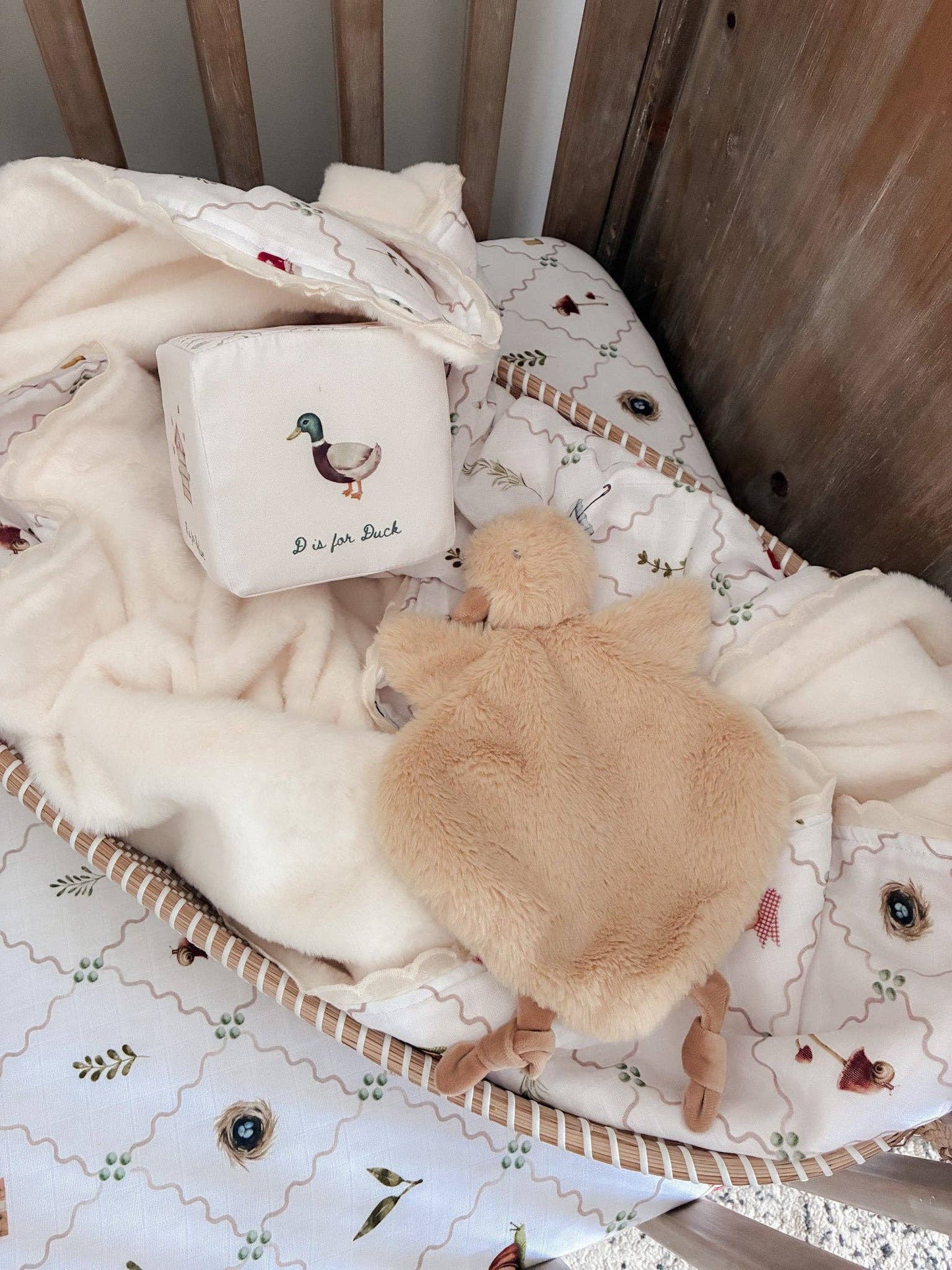 Baby crib with plush turtle toy and decorative pillow