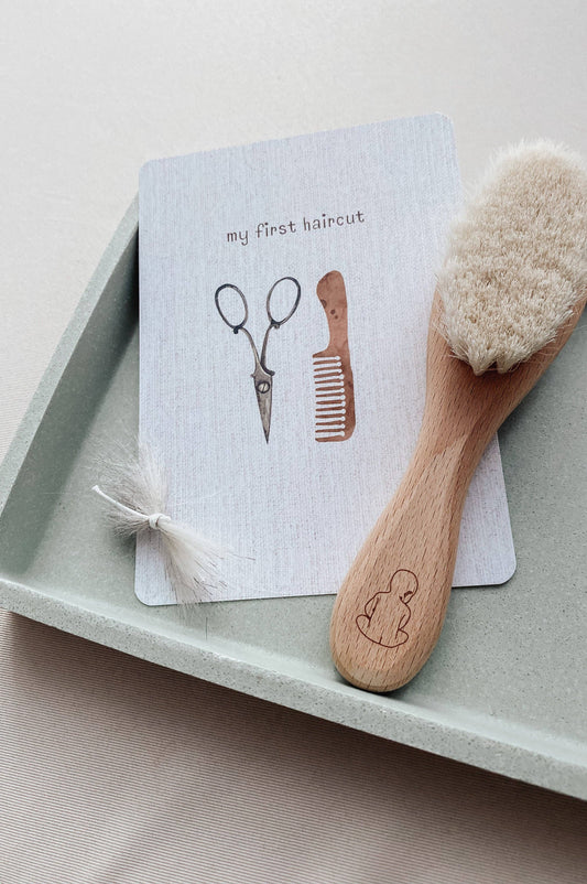 Wooden brush with bristles and a card with illustrations on a tray