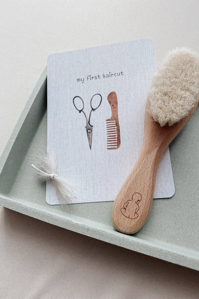 Wooden brush with bristles and a card with illustrations on a tray